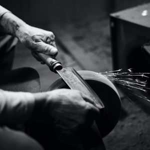person grinding cleaver